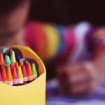 Child coloring with crayons
