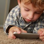 Boy playing games on a mobile phone